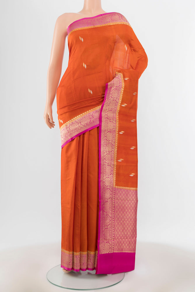 Brick Orange Banarasi Katan Silk Saree with Zari Brocade on the body and Silk Border.  displayed on a mannequin