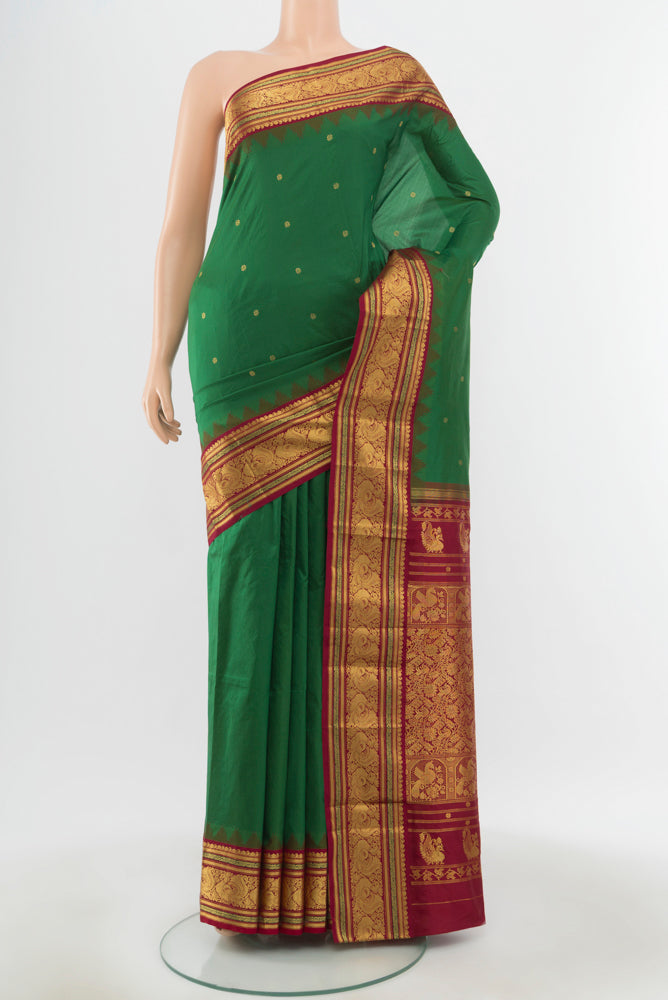 Bottle Green Pochampally Saree with Zari Butta on the body and Silk Border.  displayed on a mannequin