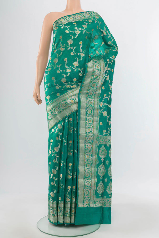 Pure Silk Pure Zari Peacock Blue Banarasi Raw Saree with Zari Butta on the body and Silk Border.  displayed on a mannequin