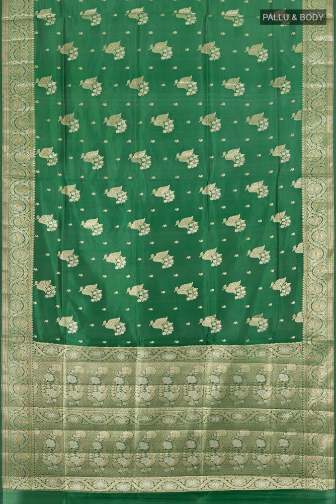 Flat view of Pure Silk Pure Zari Bottle Green Banarasi Raw Saree with Zari Butta on the body and Silk Border. 