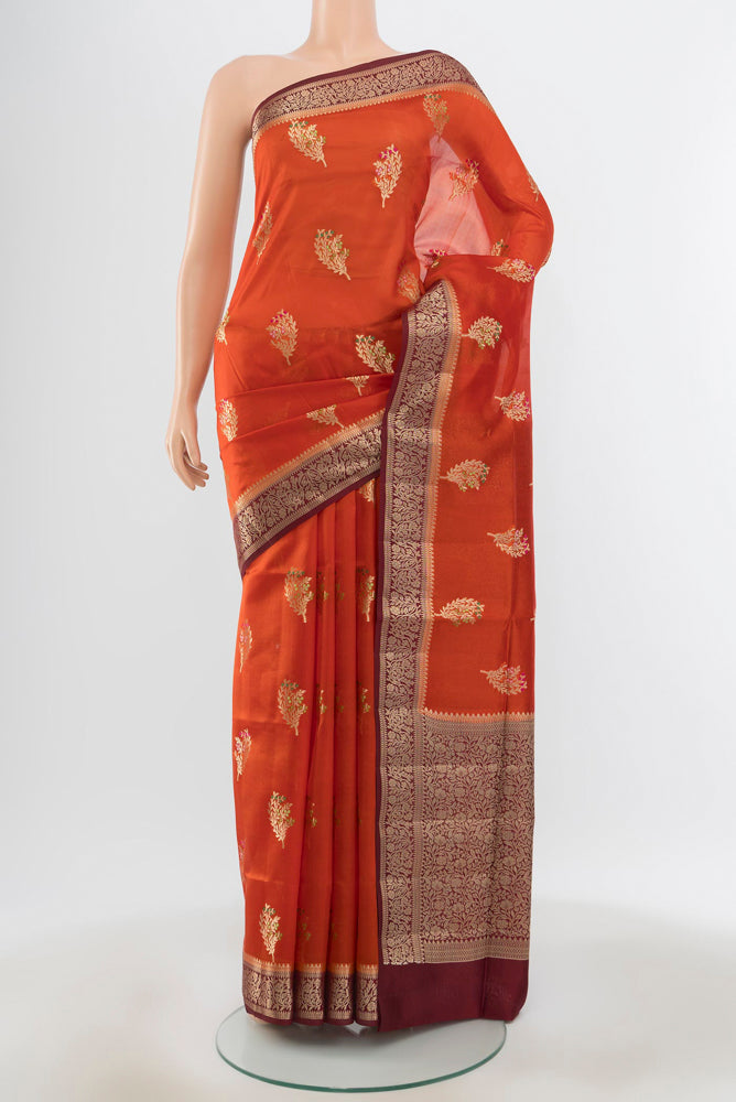 Pure Silk Pure Zari Rust Banarasi Raw Saree with Zari Butta on the body and Silk Border.  displayed on a mannequin