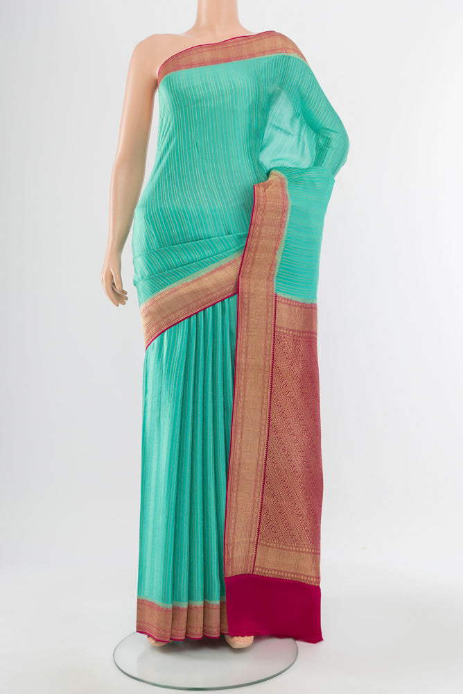 Sky Blue Mysore Crepe Saree with Zari Butta on the body and Silk Border.  displayed on a mannequin