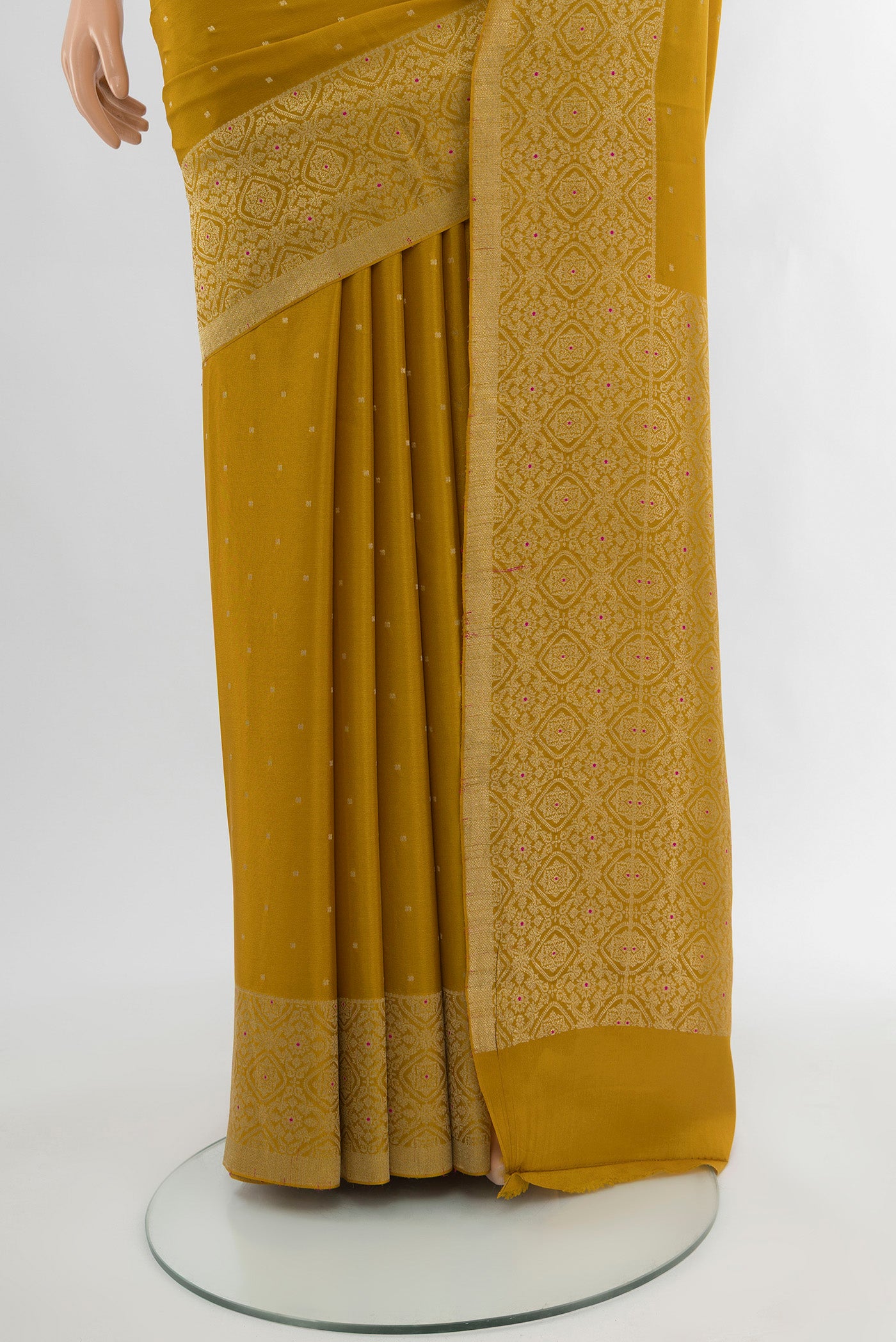 Pleats and pallu of Mustard Mysore Crepe Saree with Zari Butta on the body and Zari Border. 