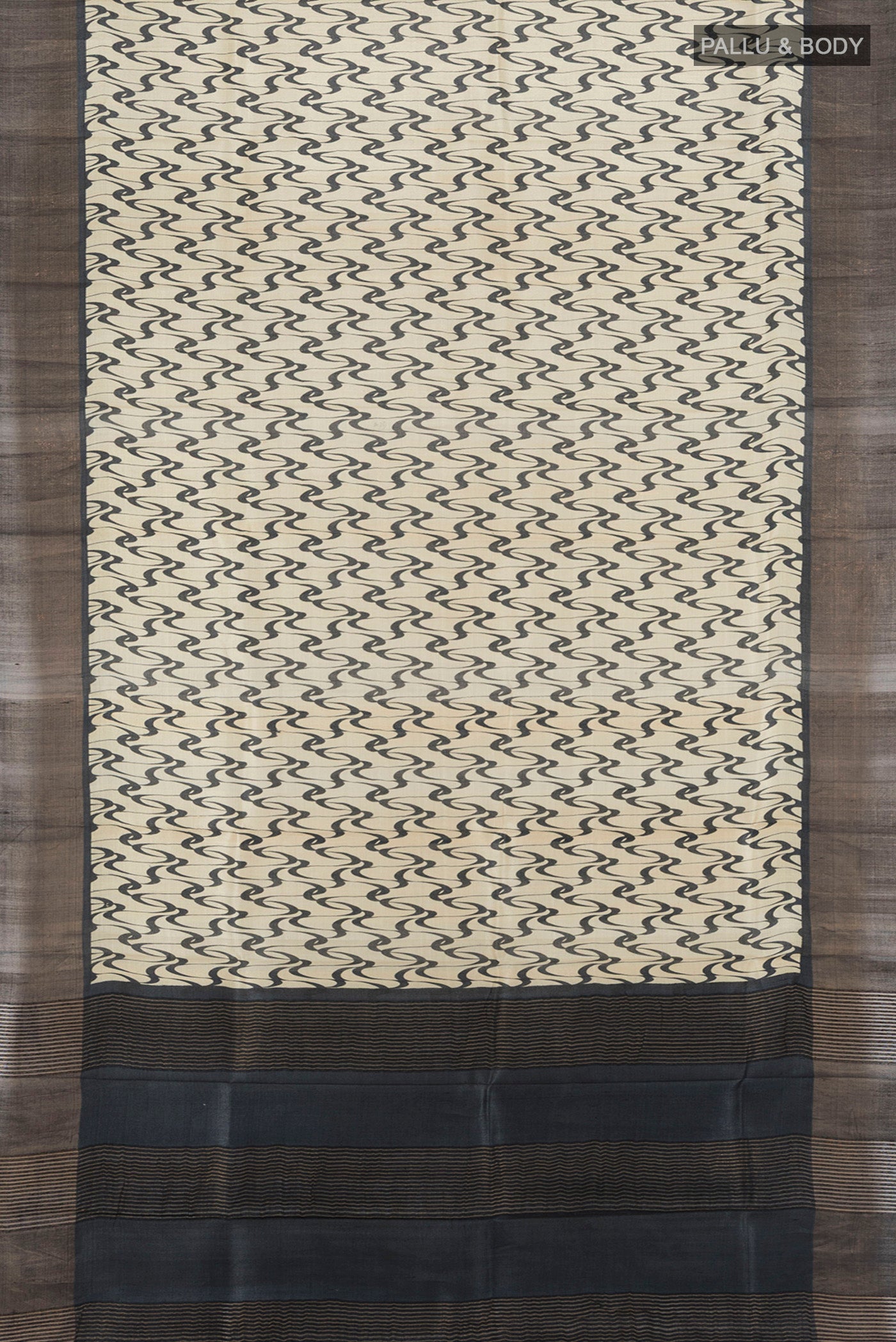 Flat view of Cream Tussar Silk Saree with Printed design on the body and Zari Border. 