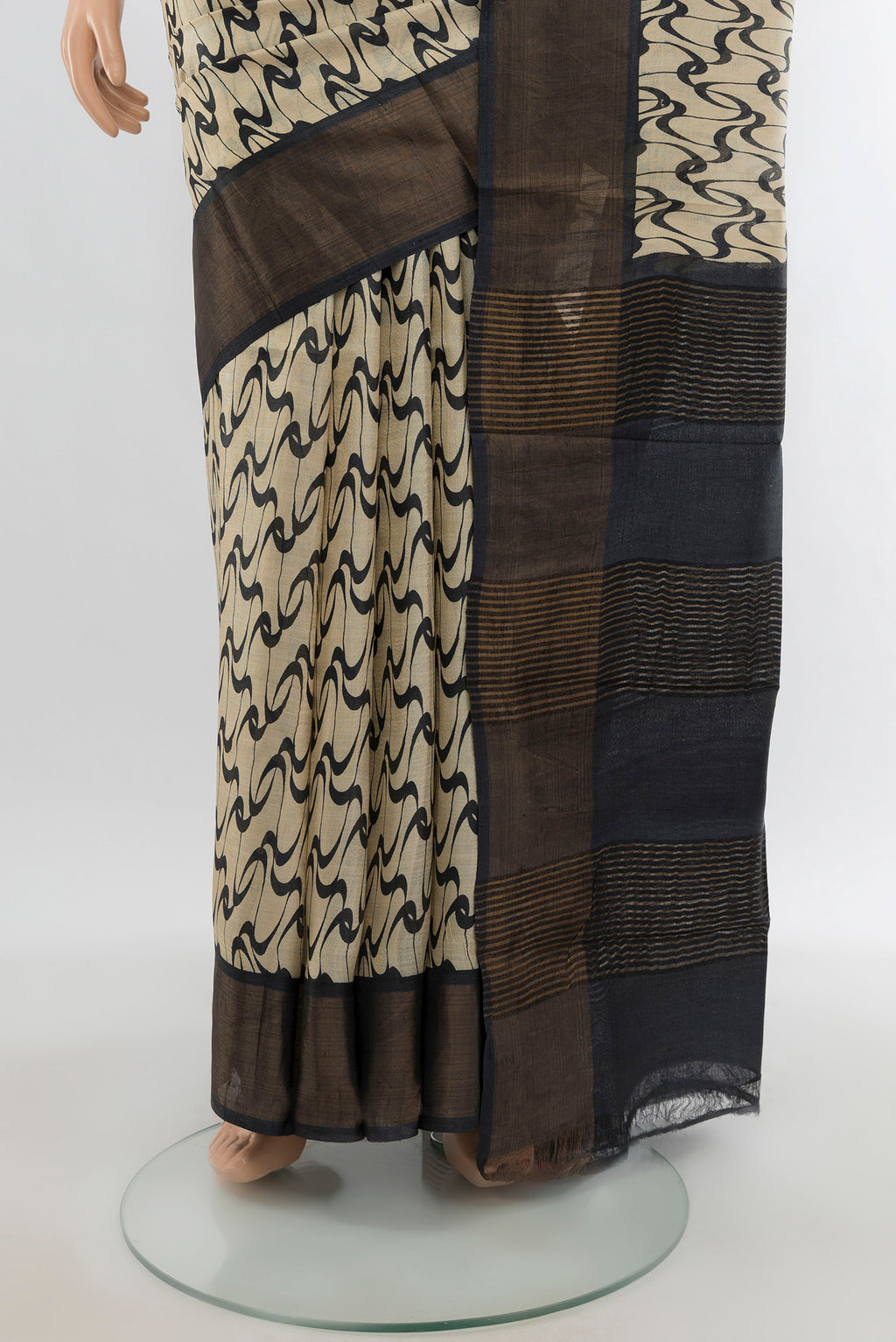 Pleats and pallu of Cream Tussar Silk Saree with Printed design on the body and Zari Border. 