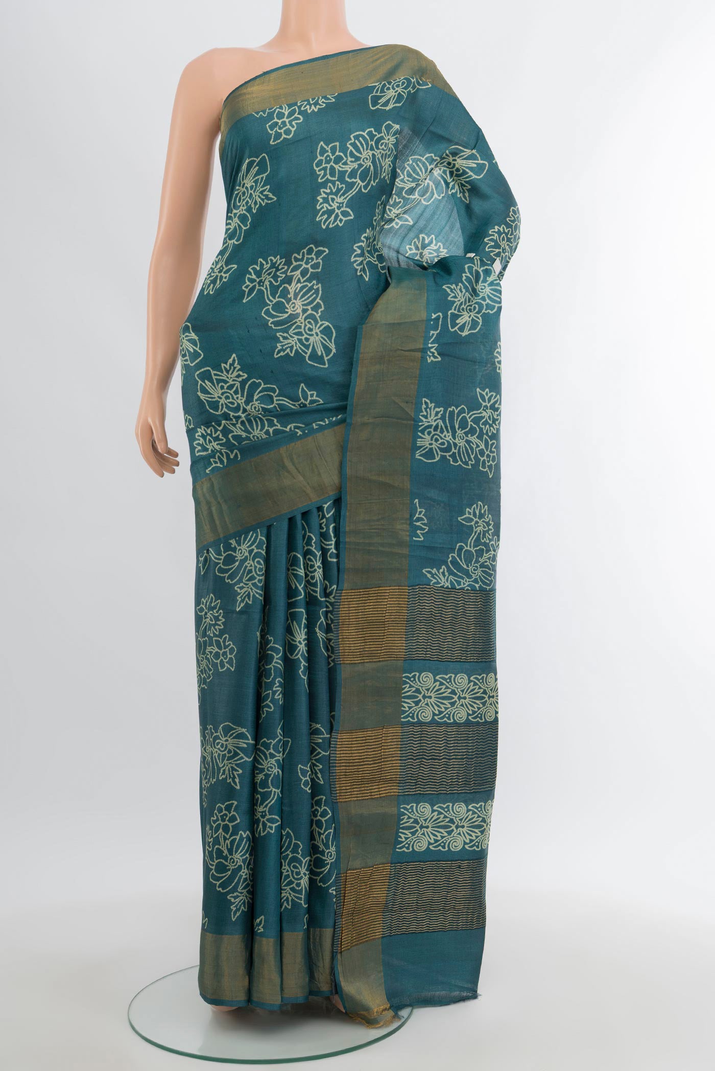 Teal Tussar Silk Saree with Floral Print on the body and Zari Border.  displayed on a mannequin