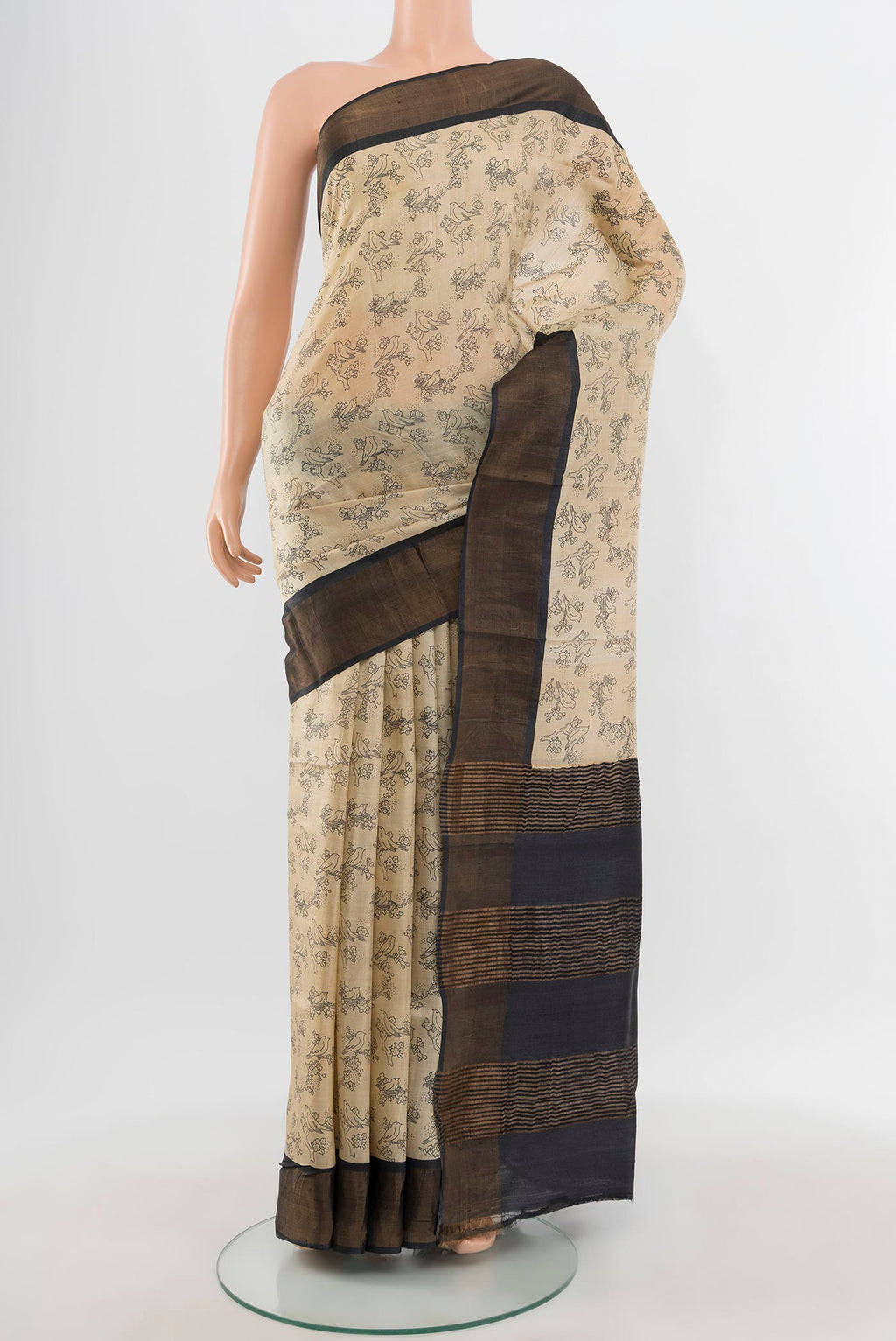 Beige Tussar Silk Saree with Floral Print on the body and Zari Border.  displayed on a mannequin