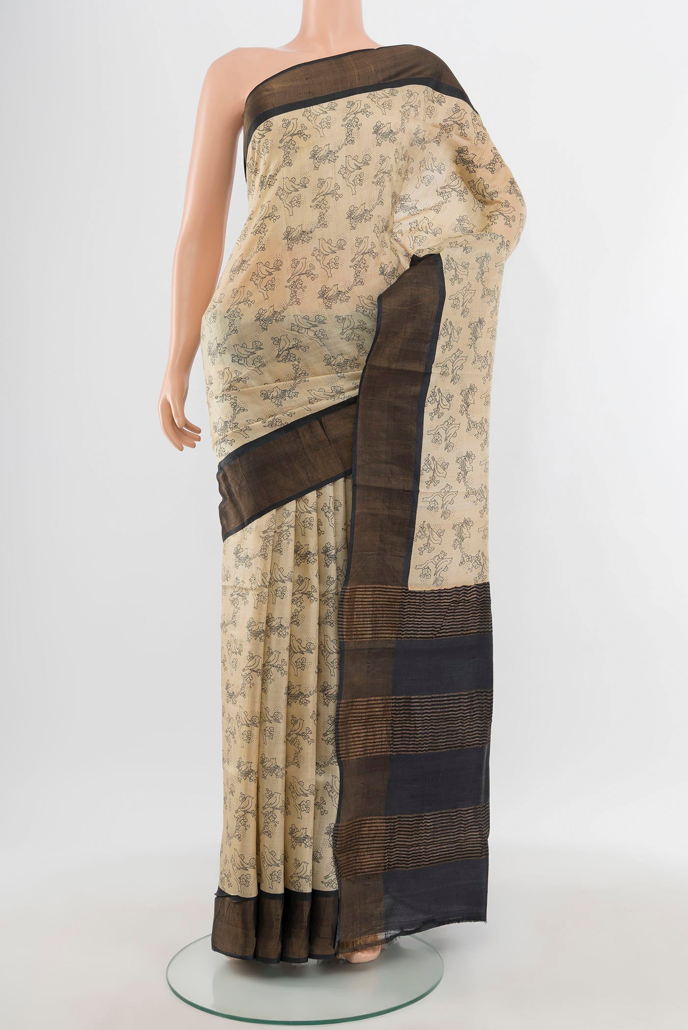 Beige Tussar Silk Saree with Floral Print on the body and Zari Border.  displayed on a mannequin
