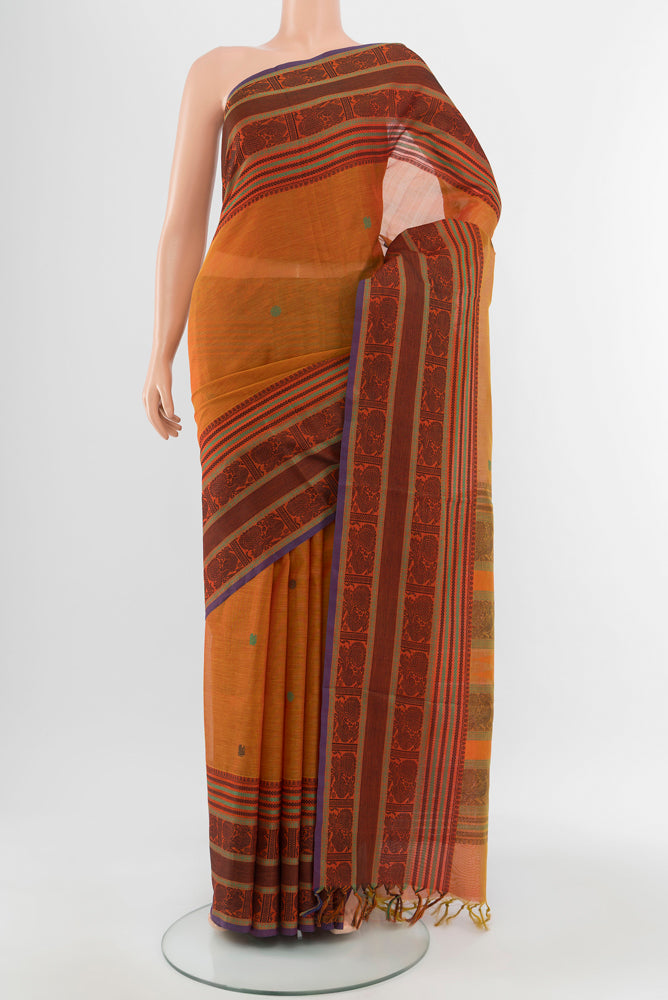 Mustard Kora Cotton Saree with Zari Butta on the body and Silk Border.  displayed on a mannequin