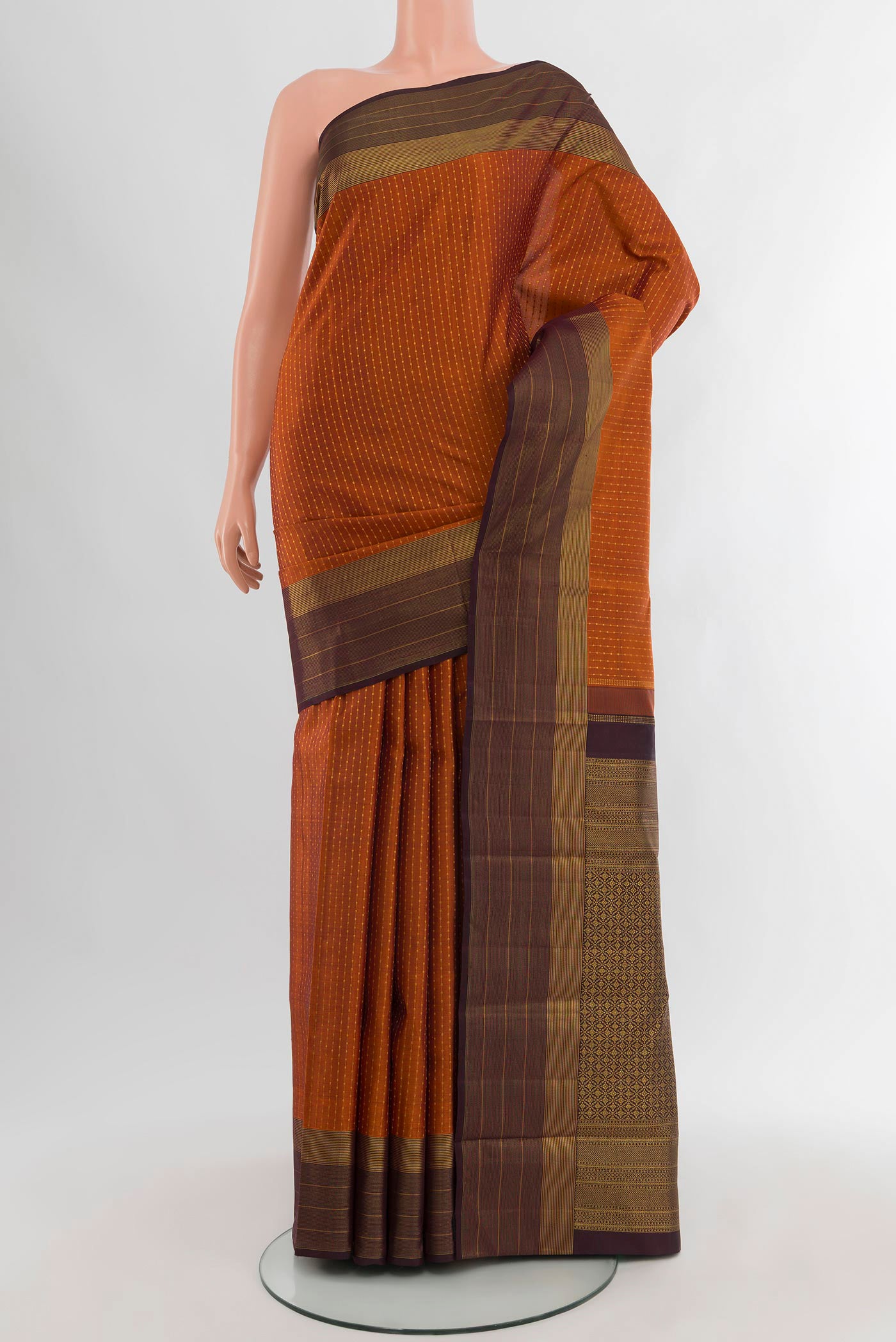 Rust Kanjivaram Silk Saree with Zari Butta on the body and Plain Border.  displayed on a mannequin