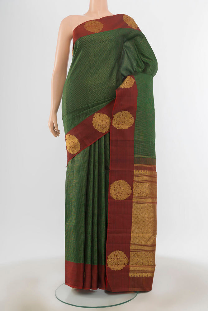 Bottle Green Kanjivaram Silk Saree with Zari Butta on the body and Silk Border.  displayed on a mannequin