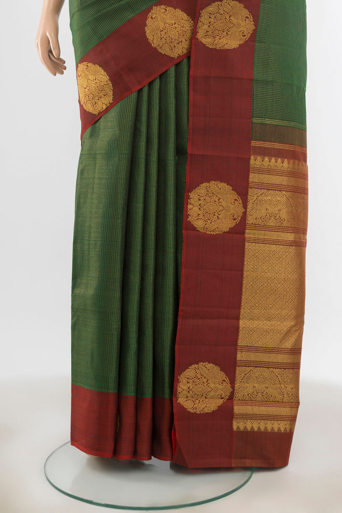 Pleats and pallu of Bottle Green Kanjivaram Silk Saree with Zari Butta on the body and Silk Border. 