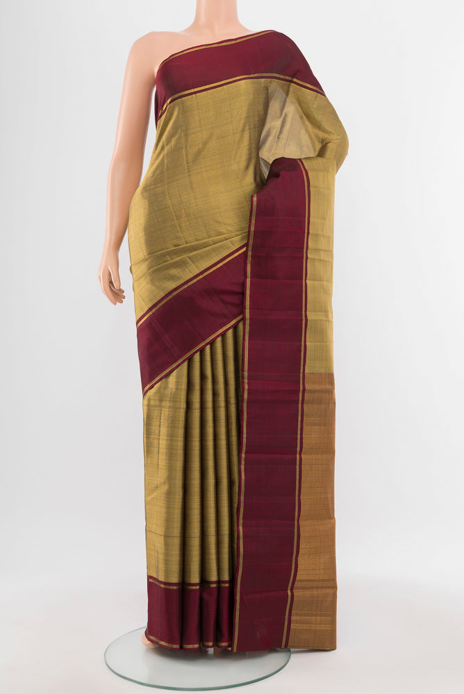 Golden Kanjivaram Silk Saree with Zari Butta on the body and Silk Border.  displayed on a mannequin