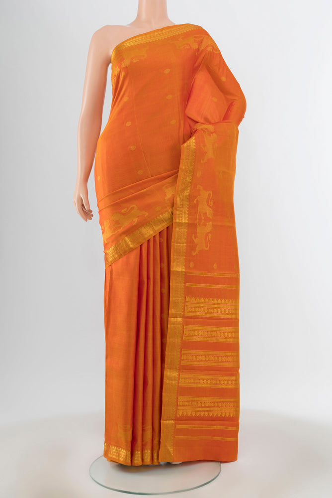Orange Kanjivaram Silk Saree with Zari Butta on the body and Silk Border.  displayed on a mannequin