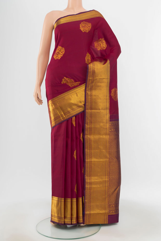 Pure Silk Pure Zari Maroon Kanjivaram Saree with Zari Butta on the body and Silk Border.  displayed on a mannequin