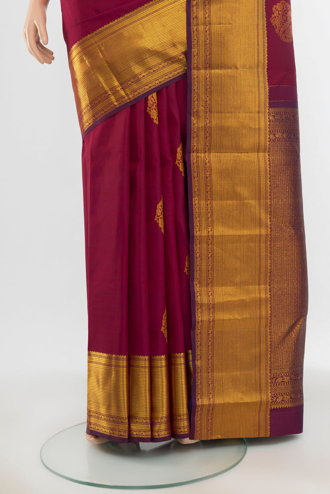 Pleats and pallu of Pure Silk Pure Zari Maroon Kanjivaram Saree with Zari Butta on the body and Silk Border. 