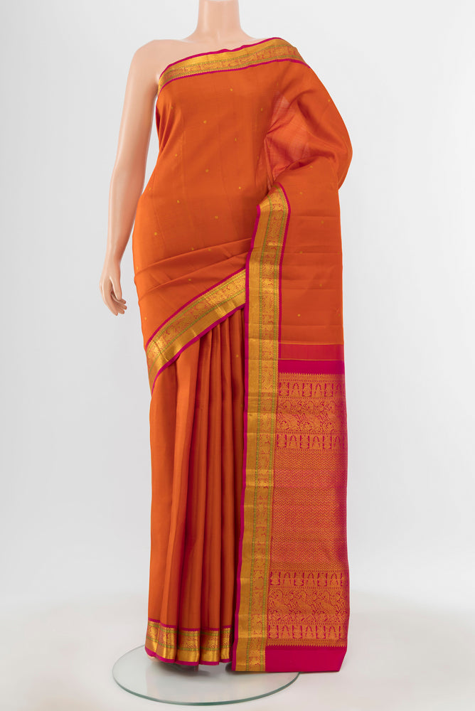 Pure Silk Pure Zari Rust Kanjivaram Saree with Zari Butta on the body and Silk Border.  displayed on a mannequin