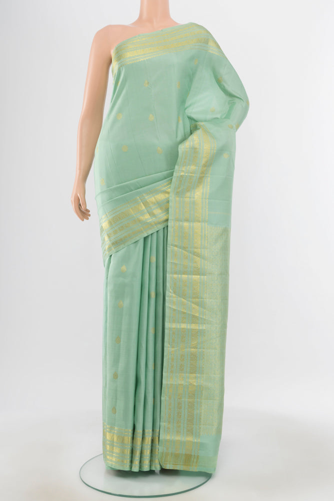 Pure Silk Pure Zari Pista Green Kanjivaram Saree with Zari Butta on the body and Silk Border.  displayed on a mannequin