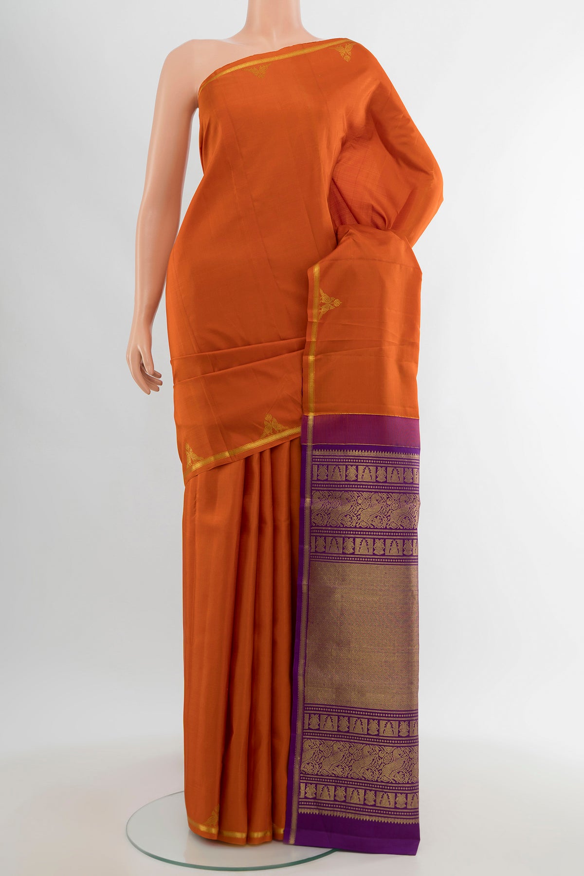 Orange Kanchipuram Silk Saree with Zari Butta on the body and Zari Border.  displayed on a mannequin