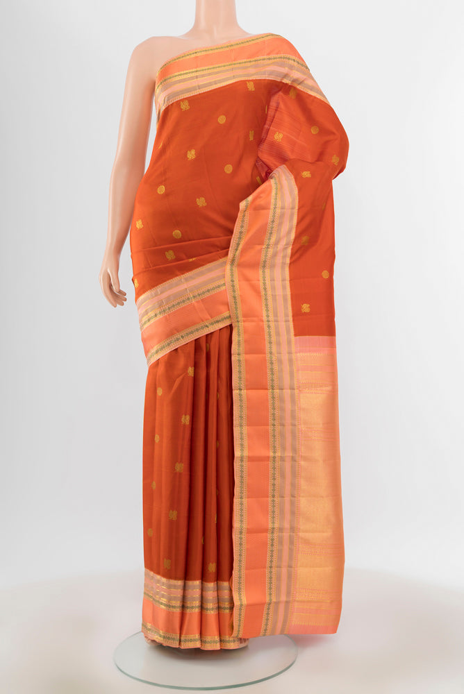 Pure Silk Pure Zari Rust Kanjivaram Saree with Zari Butta on the body and Silk Border.  displayed on a mannequin