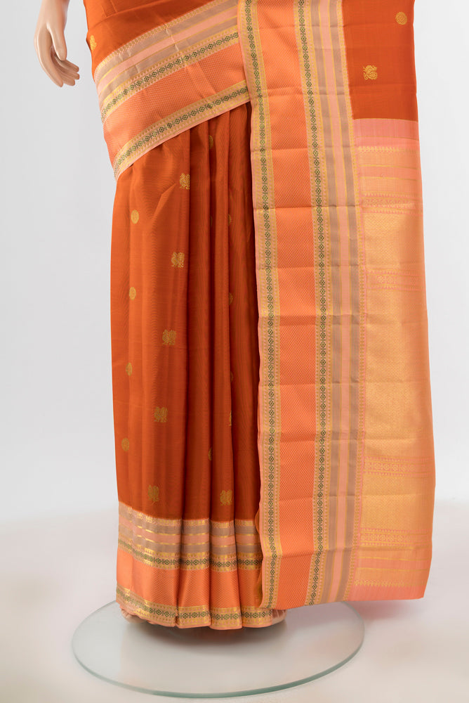 Pleats and pallu of Pure Silk Pure Zari Rust Kanjivaram Saree with Zari Butta on the body and Silk Border. 