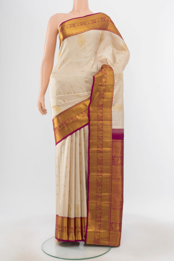 Pure Silk Pure Zari Cream Kanjivaram Saree with Zari Butta on the body and Silk Border.  displayed on a mannequin