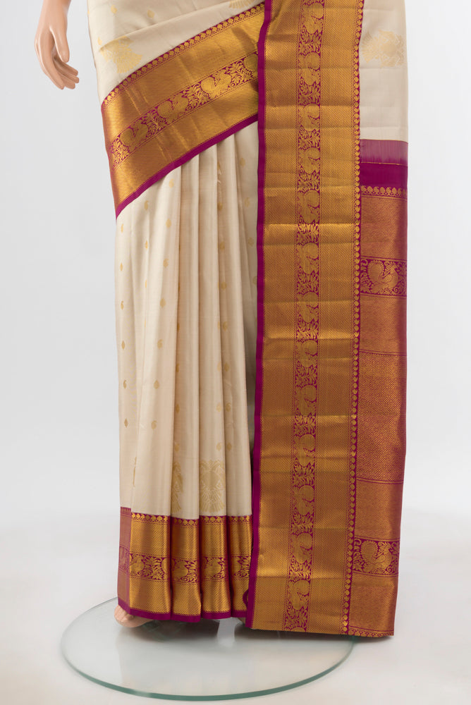 Pleats and pallu of Pure Silk Pure Zari Cream Kanjivaram Saree with Zari Butta on the body and Silk Border. 