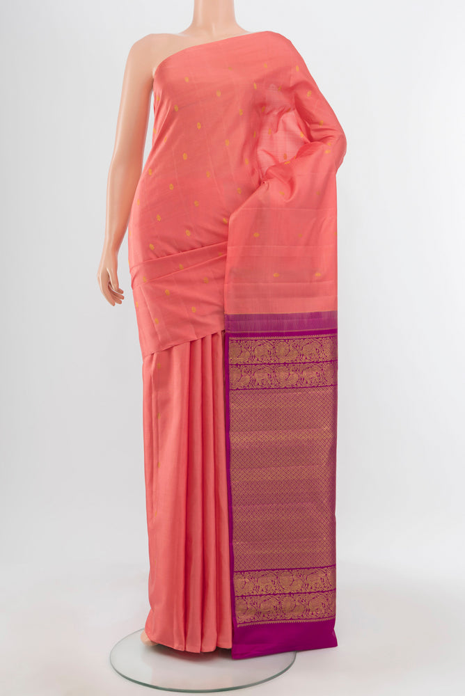 Peach Kanchipuram Silk Saree with Zari Butta on the body and Silk Border.  displayed on a mannequin