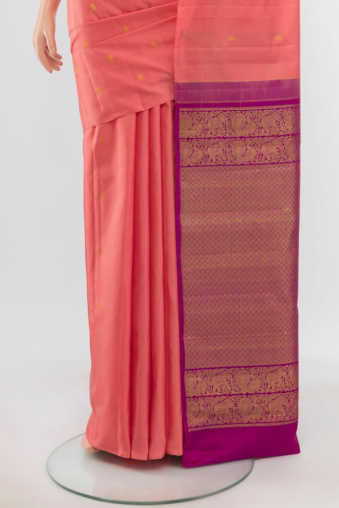Pleats and pallu of Peach Kanchipuram Silk Saree with Zari Butta on the body and Silk Border. 