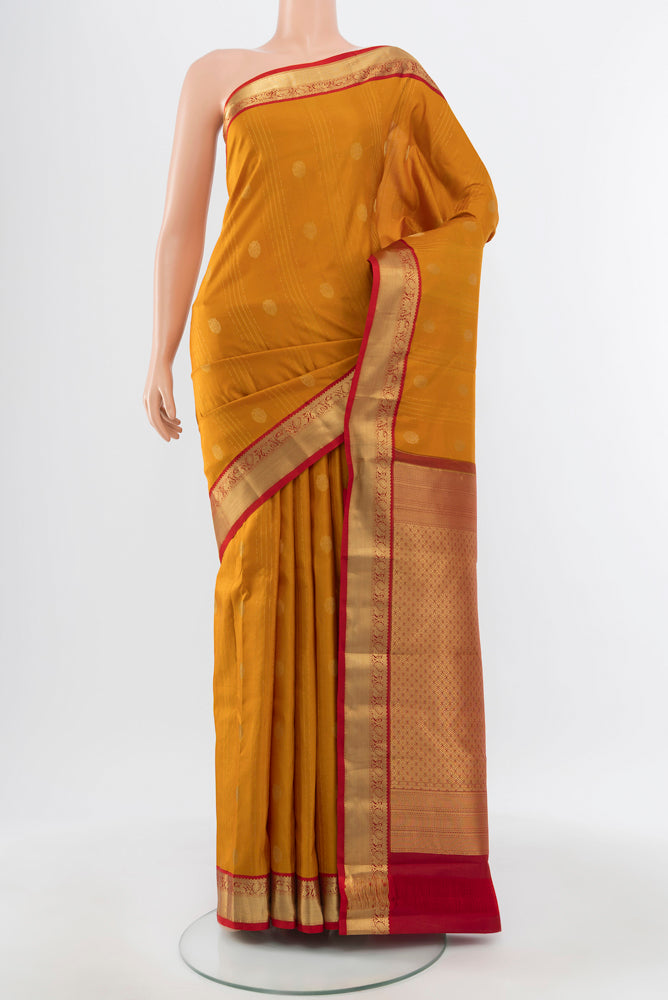 Pure Silk Pure Zari Mustard Kanchipuram Saree with Zari Brocade on the body and Silk Border.  displayed on a mannequin