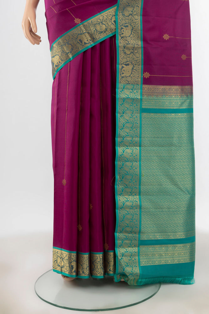 Pleats and pallu of Purple Kanchipuram Silk Saree with Zari Butta on the body and Silk Border. 