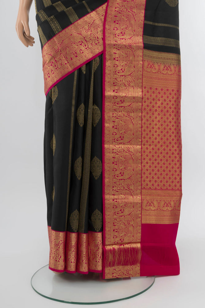 Pleats and pallu of Black Kanchipuram Silk Saree with Zari Butta on the body and Silk Border. 