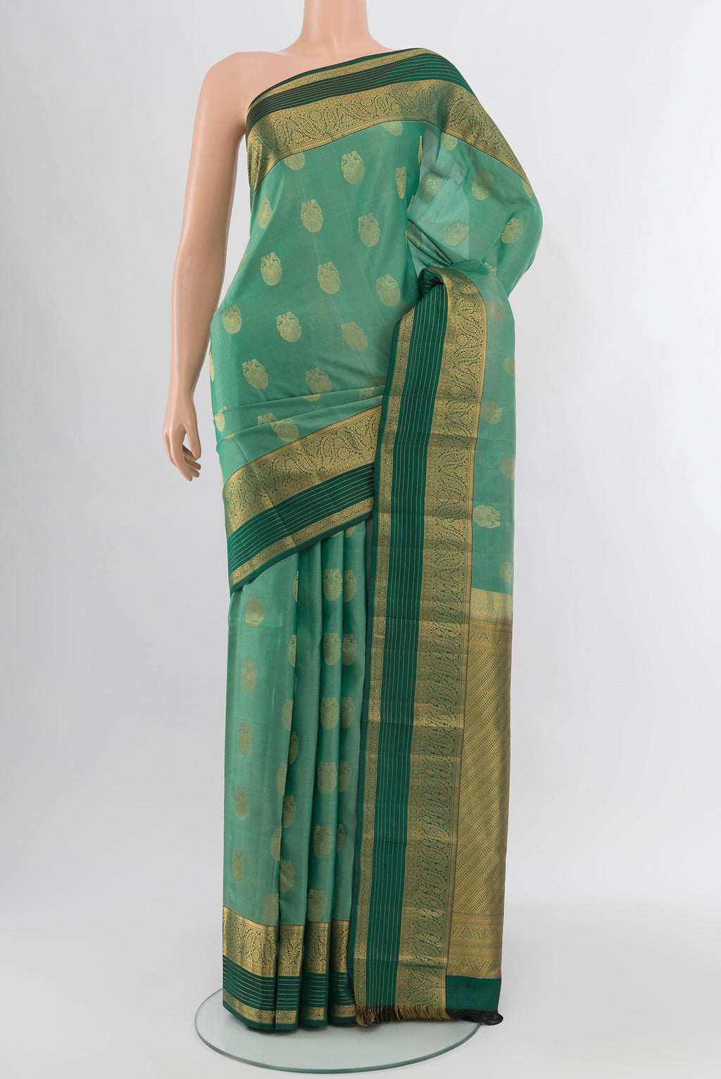 Light Green Kanchipuram Silk Saree with Zari Butta on the body and Zari Border.  displayed on a mannequin