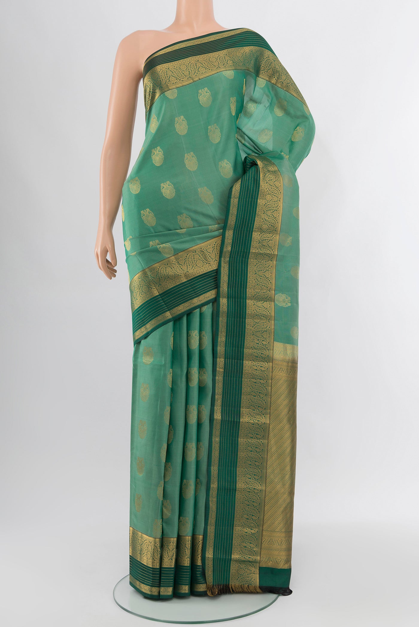 Light Green Kanchipuram Silk Saree with Zari Butta on the body and Zari Border.  displayed on a mannequin