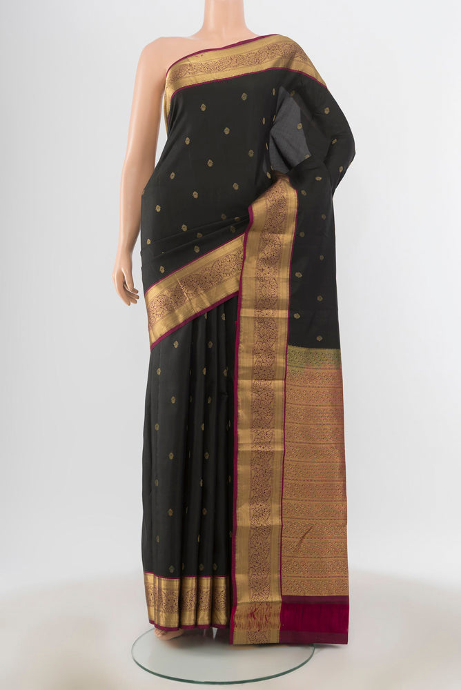 Black Kanchipuram Silk Saree with Zari Butta on the body and Silk Border.  displayed on a mannequin