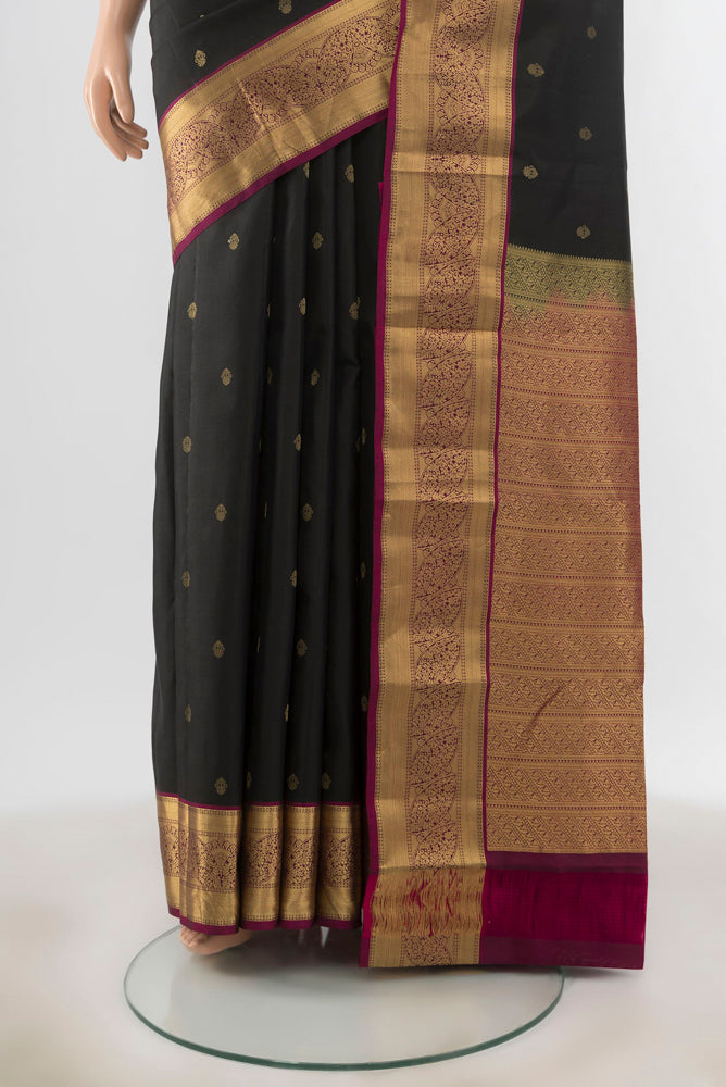 Pleats and pallu of Black Kanchipuram Silk Saree with Zari Butta on the body and Silk Border. 