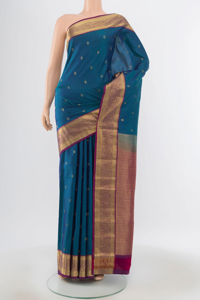 Peacock Blue Kanchipuram Silk Saree with Zari Butta on the body and Silk Border.  displayed on a mannequin