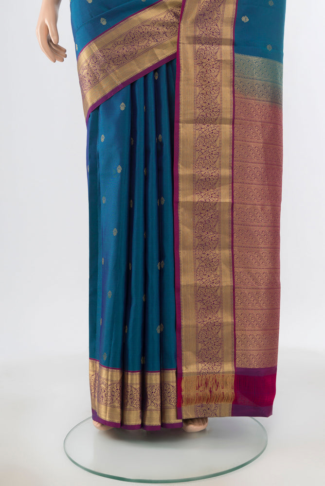 Pleats and pallu of Peacock Blue Kanchipuram Silk Saree with Zari Butta on the body and Silk Border. 