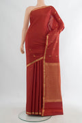Pure Silk Rust Kanjivaram Saree with Zari Butta on the body and Zari Border.  displayed on a mannequin