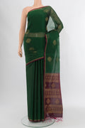 Bottle Green Silk Cotton Saree with Zari Butta on the body and Zari Border.  displayed on a mannequin