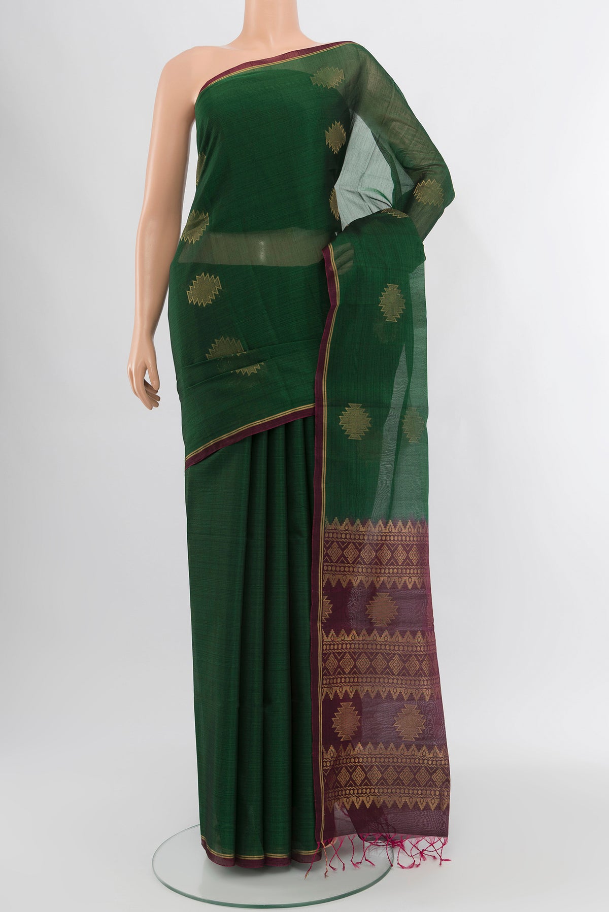 Bottle Green Silk Cotton Saree with Zari Butta on the body and Zari Border.  displayed on a mannequin