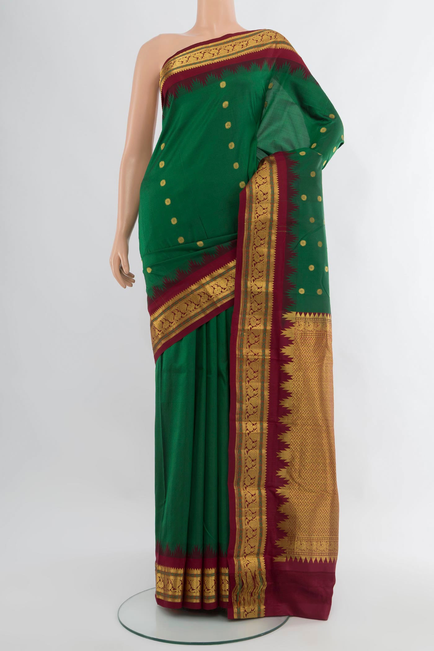 Bottle Green Kanchipuram Silk Saree with Zari Butta on the body and Zari Border.  displayed on a mannequin