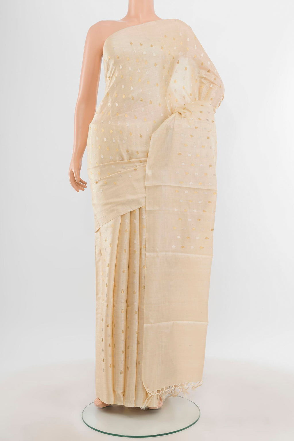Cream Tussar Silk Saree with Zari Butta on the body and Zari Border.  displayed on a mannequin