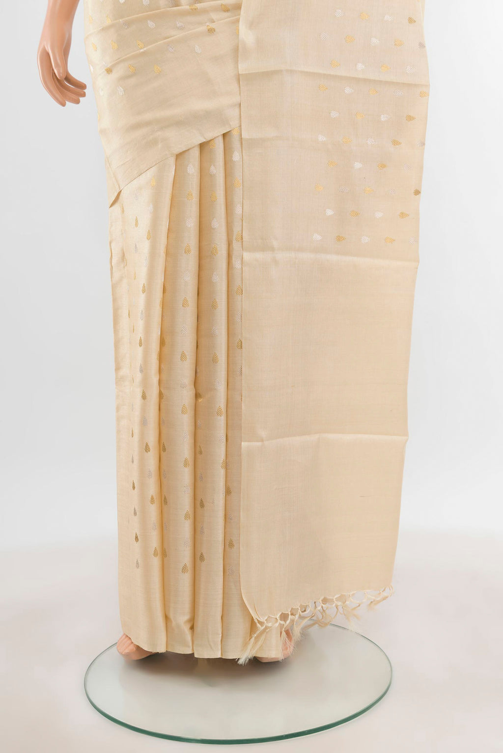 Pleats and pallu of Cream Tussar Silk Saree with Zari Butta on the body and Zari Border. 