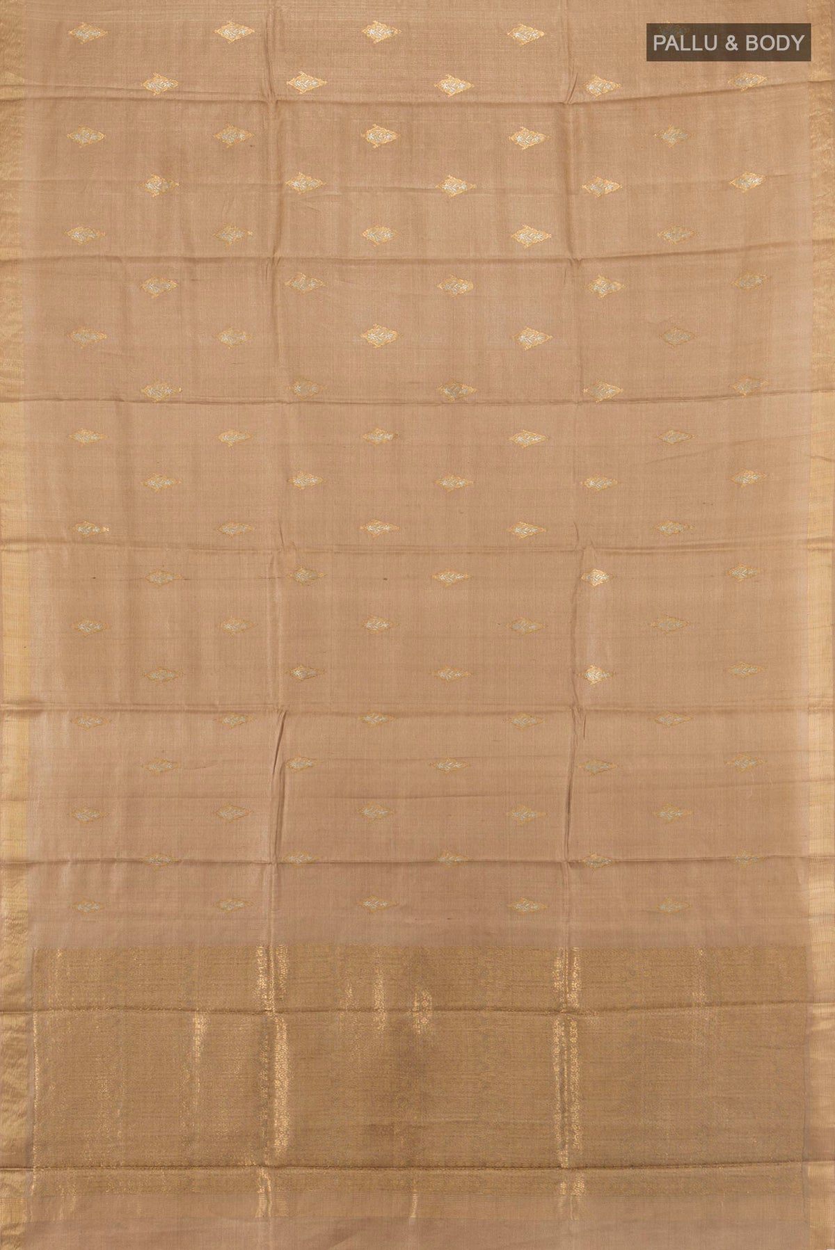 Flat view of Beige Tussar Saree with Zari Butta on the body and Zari Border. 