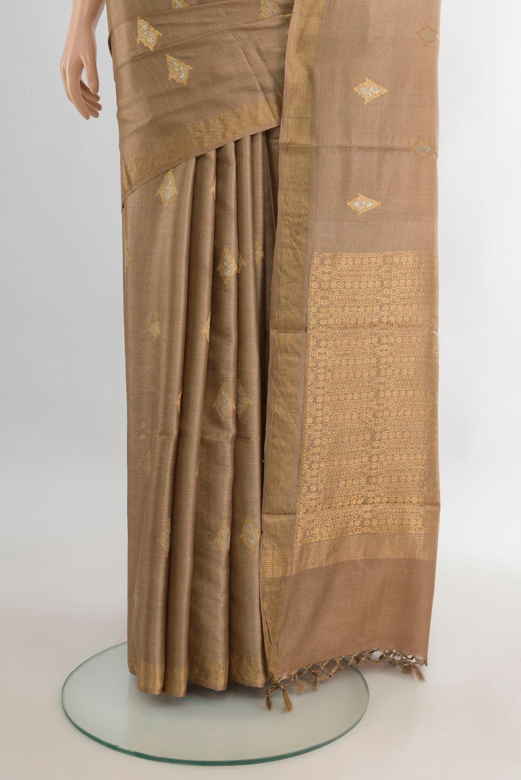 Pleats and pallu of Beige Tussar Saree with Zari Butta on the body and Zari Border. 