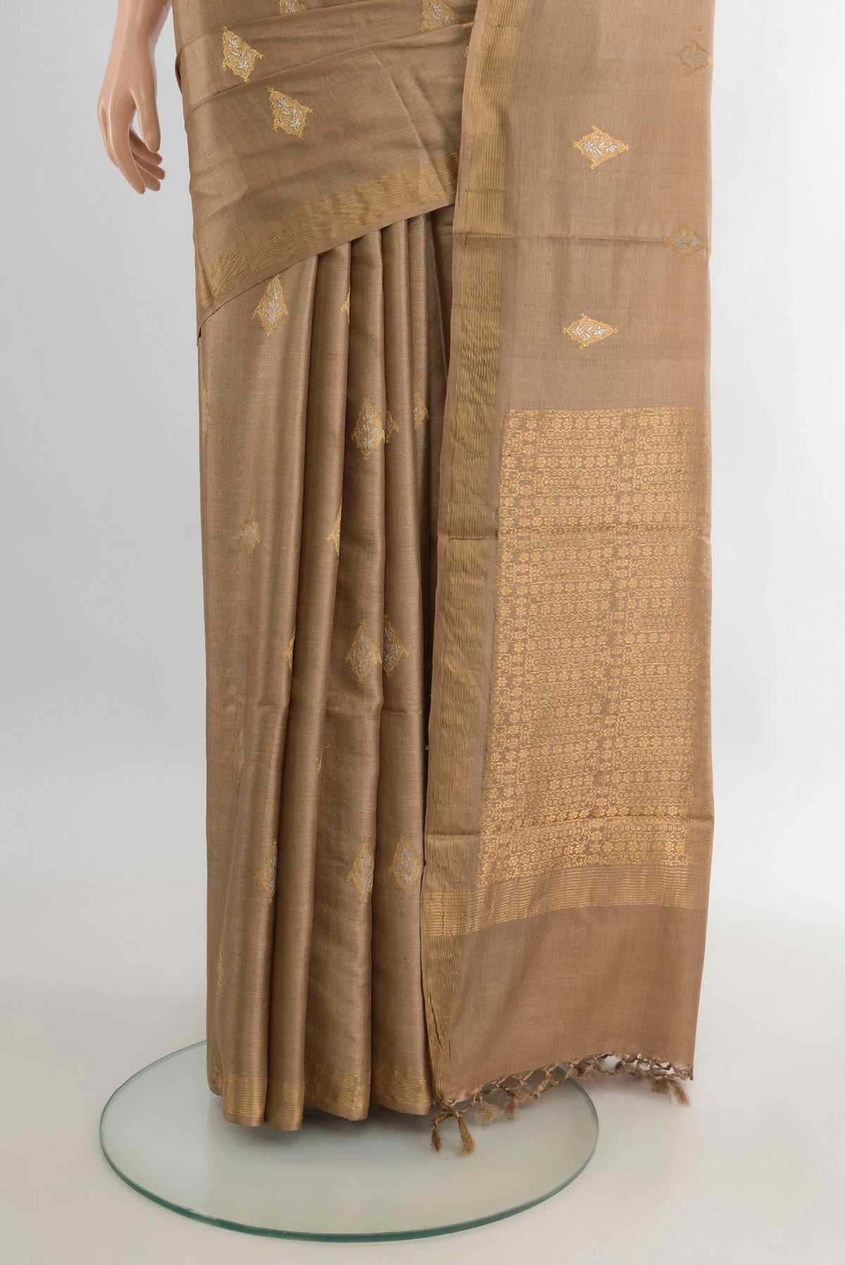 Pleats and pallu of Beige Tussar Saree with Zari Butta on the body and Zari Border. 