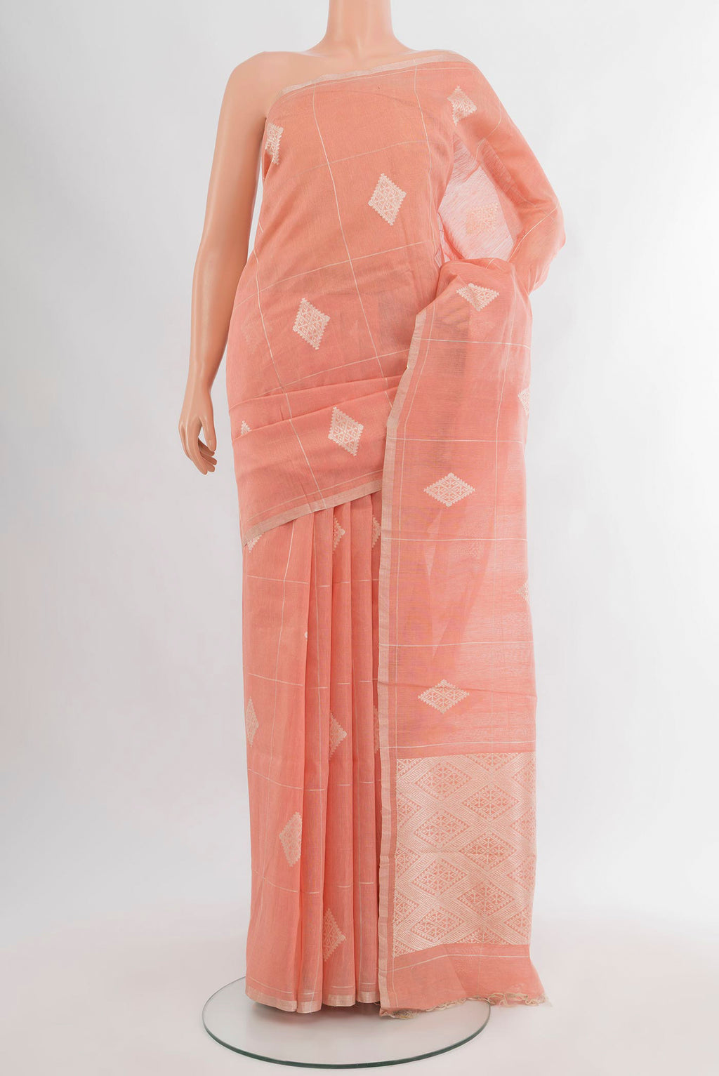 Peach Tussar Silk Saree with Checked design on the body and Zari Border.  displayed on a mannequin