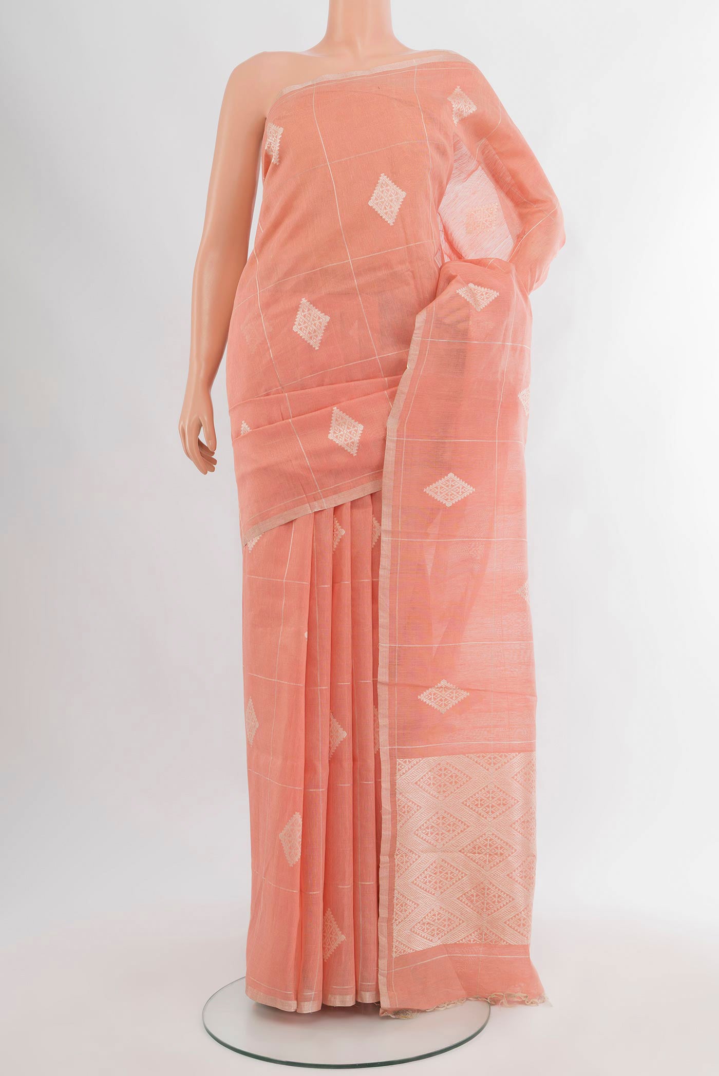 Peach Tussar Silk Saree with Checked design on the body and Zari Border.  displayed on a mannequin