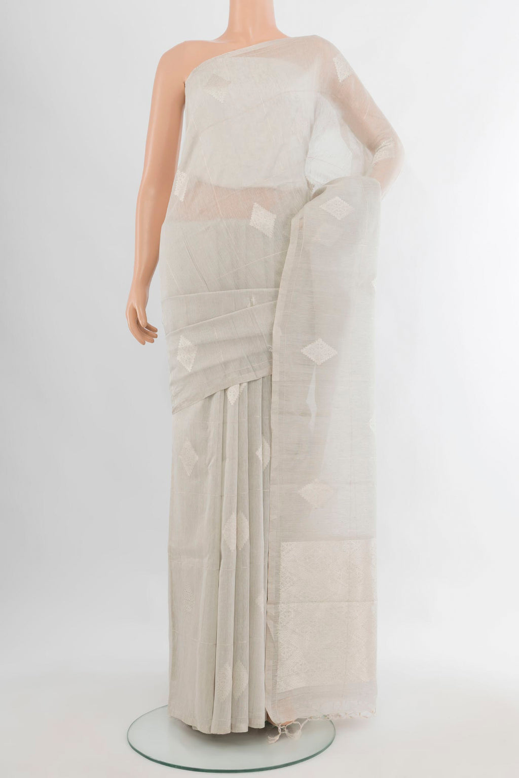 Grey Tussar Saree with Zari Butta on the body and Without Border.  displayed on a mannequin